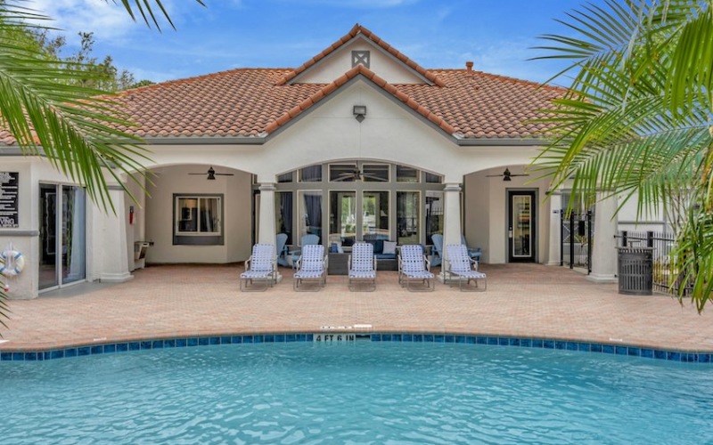 Pool with ample lounge seating and lush greenery surrounding it