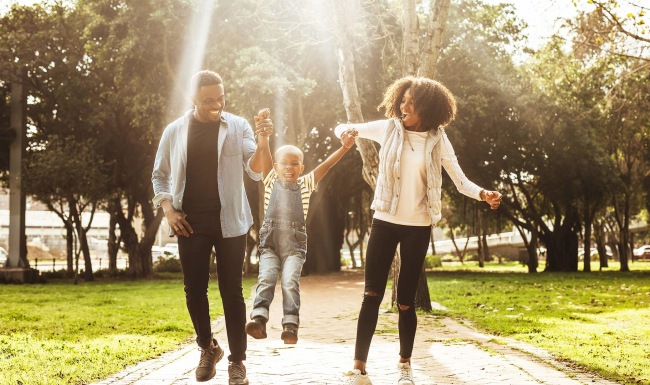 Vibrant Spaces couple walking with their child skipping on a path