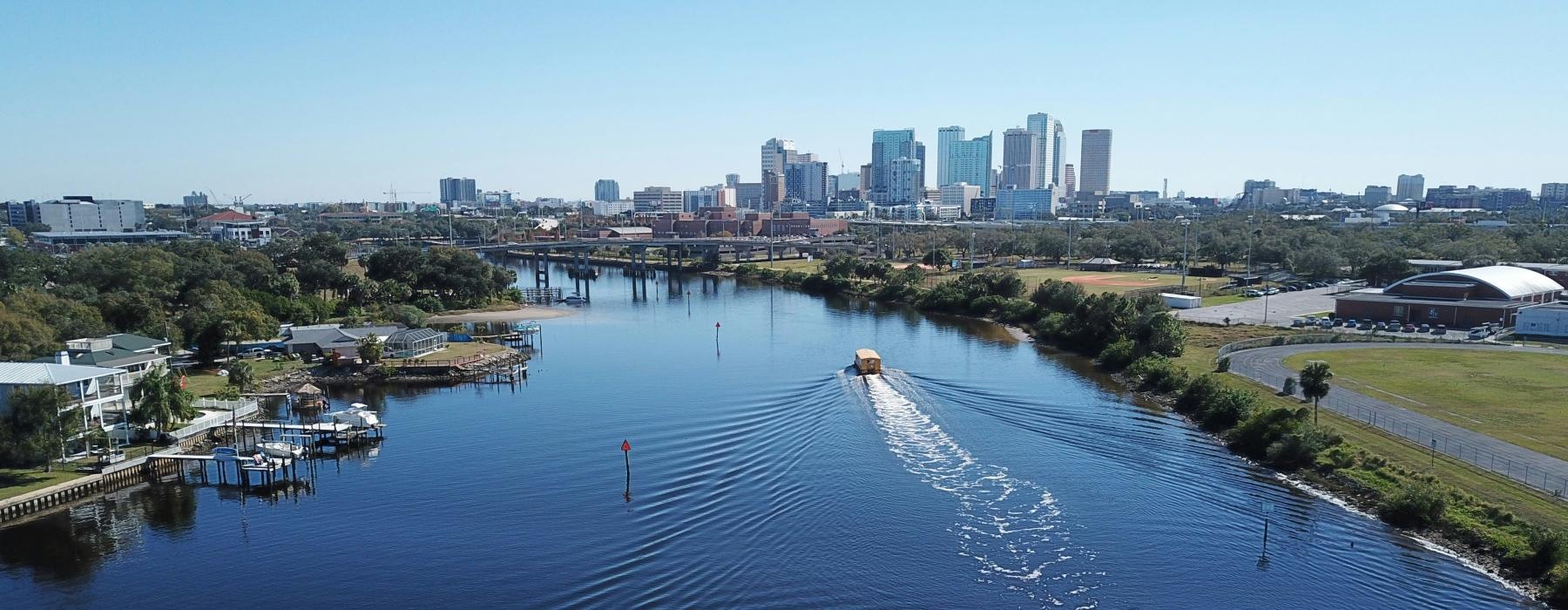 a body of water with boats in it and a city in the background