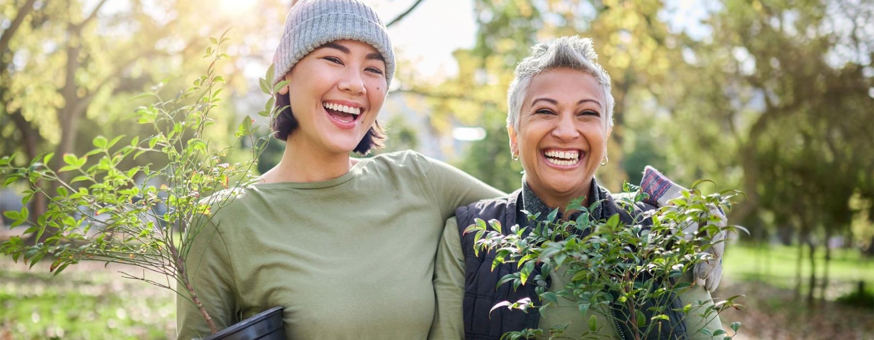 a couple of women holding plants